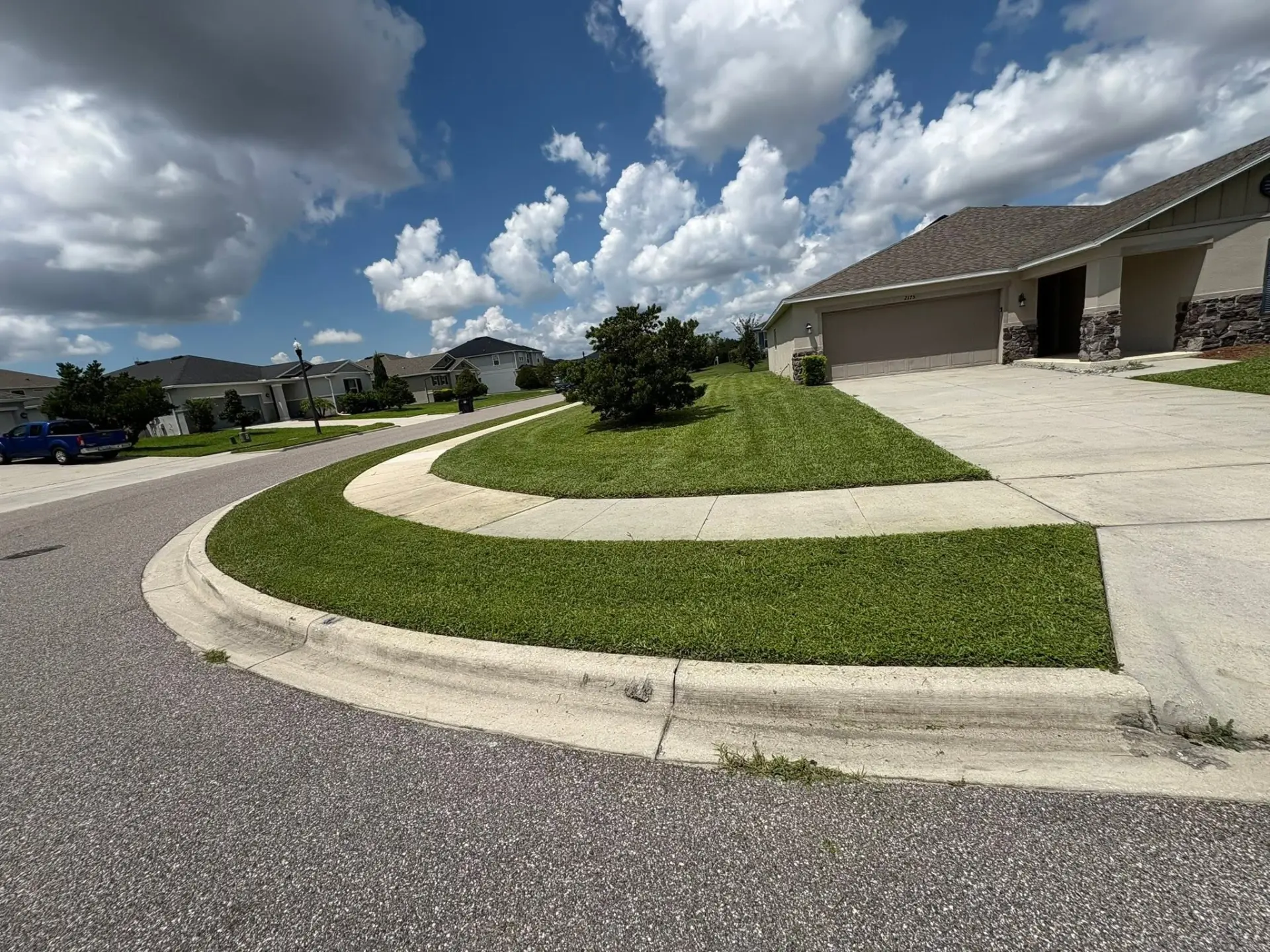 Freshly mown corner lawn with crisp sidewalk edges maintained by Molina Lawncare
